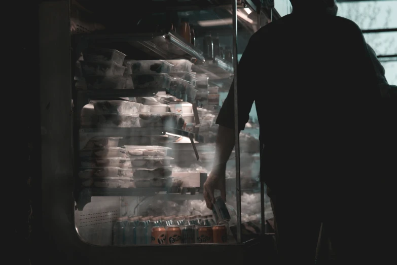 a man walks past an refrigeration station filled with refrigerators