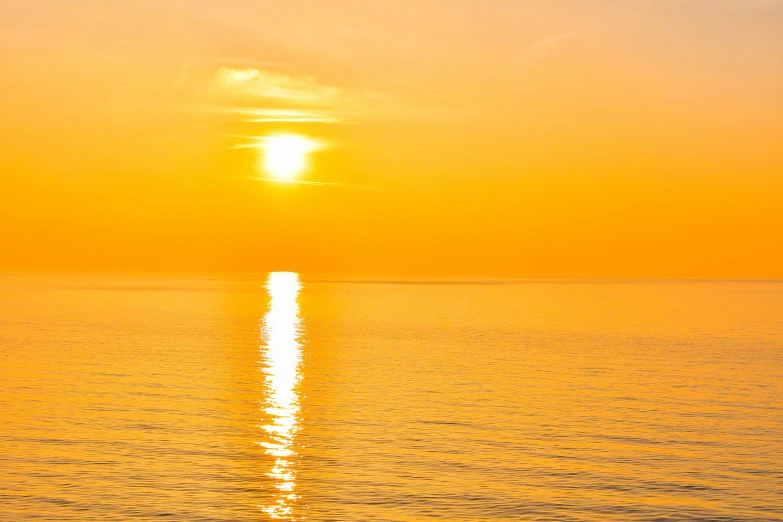 a sunset seen over the ocean on the horizon