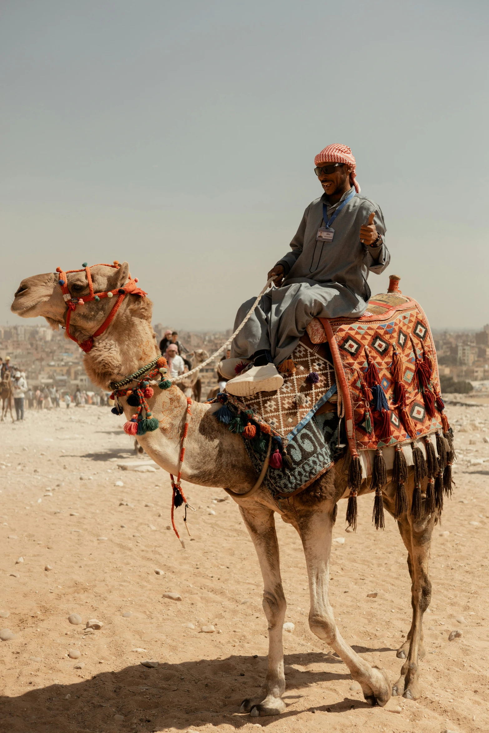 the man is riding on the camel in the desert