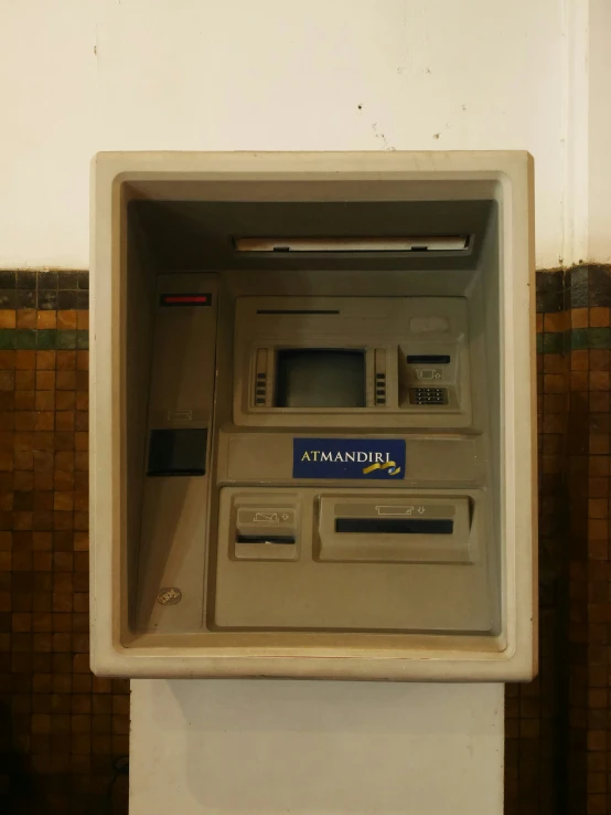 an atm machine is on a white shelf