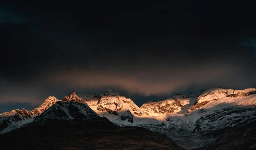 a mountain is illuminated by the last rays of sun