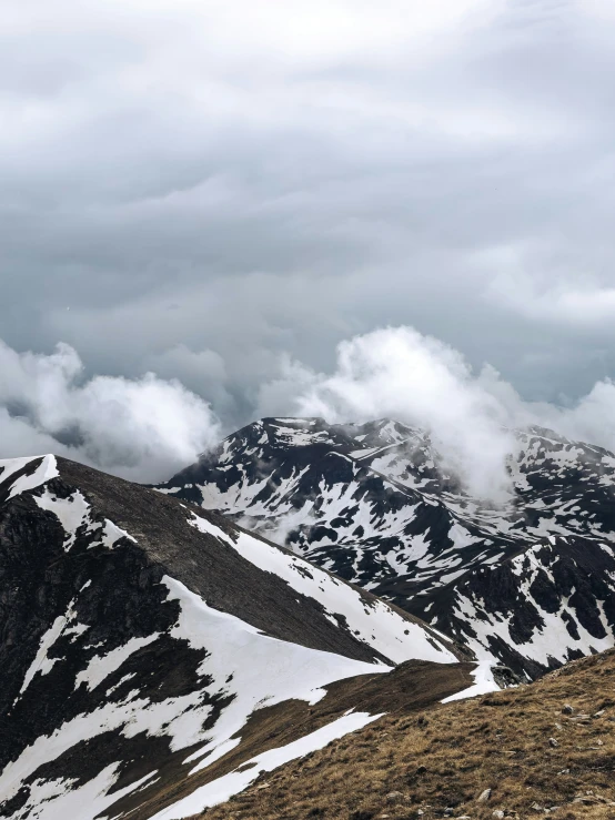 three people stand on top of a mountain