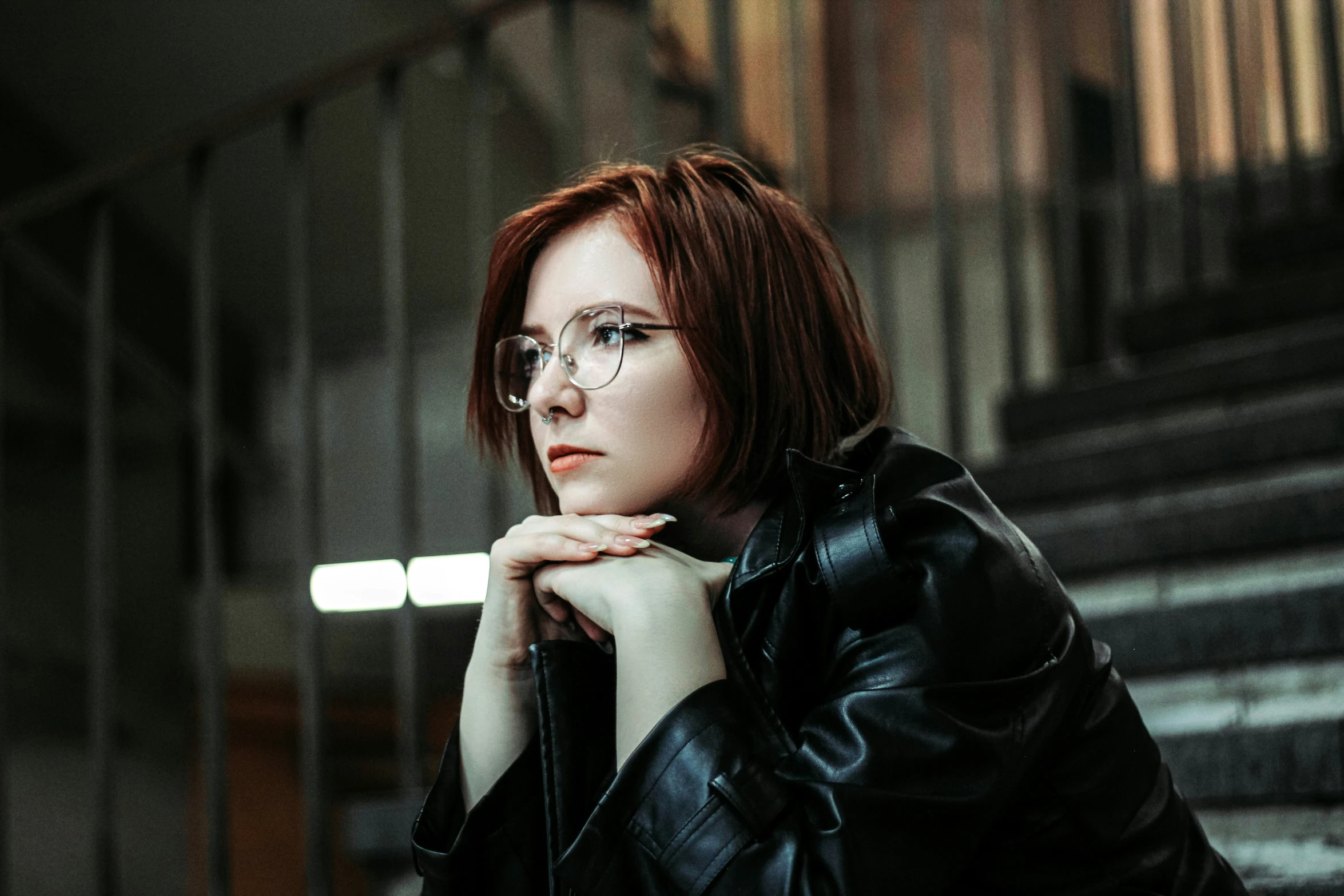 a young woman in glasses looks to the side