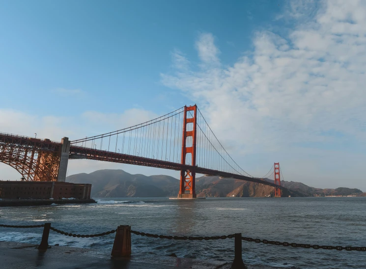 the golden gate bridge is framed by water and clouds