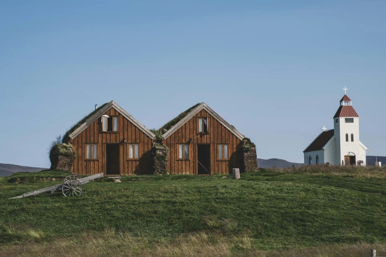 two little church like houses sit in a grassy area