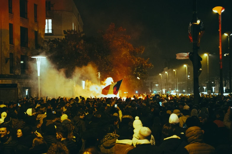 a very large crowd of people standing in a street