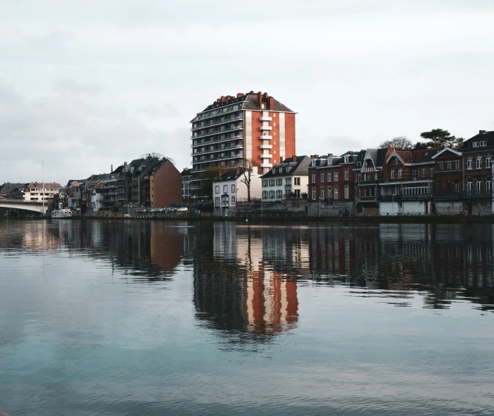 the buildings sit close to the river that is flowing through a city