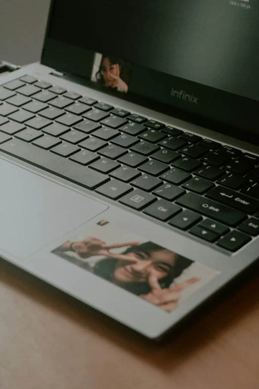 a black computer with two pictures of people