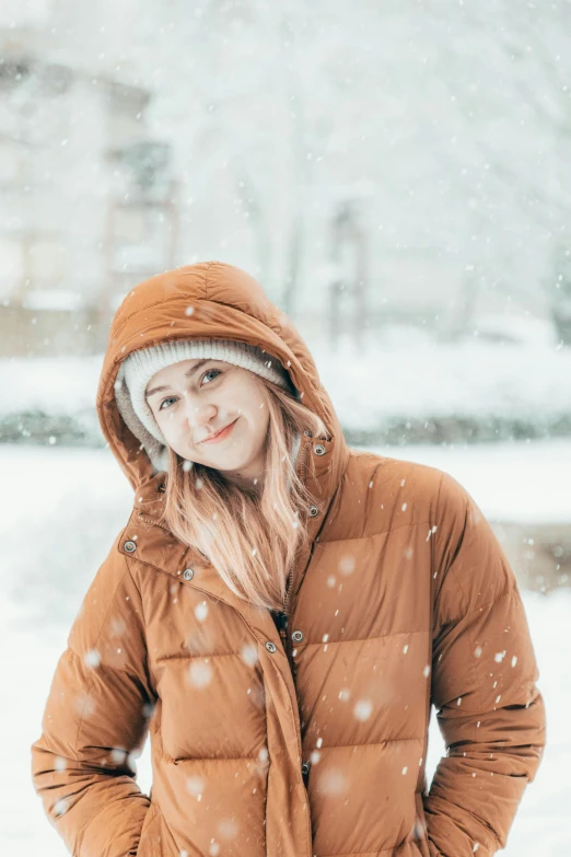 a woman in a brown jacket standing outside in the snow