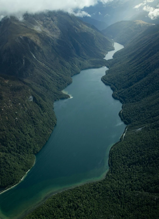 a plane flying over mountains above a body of water