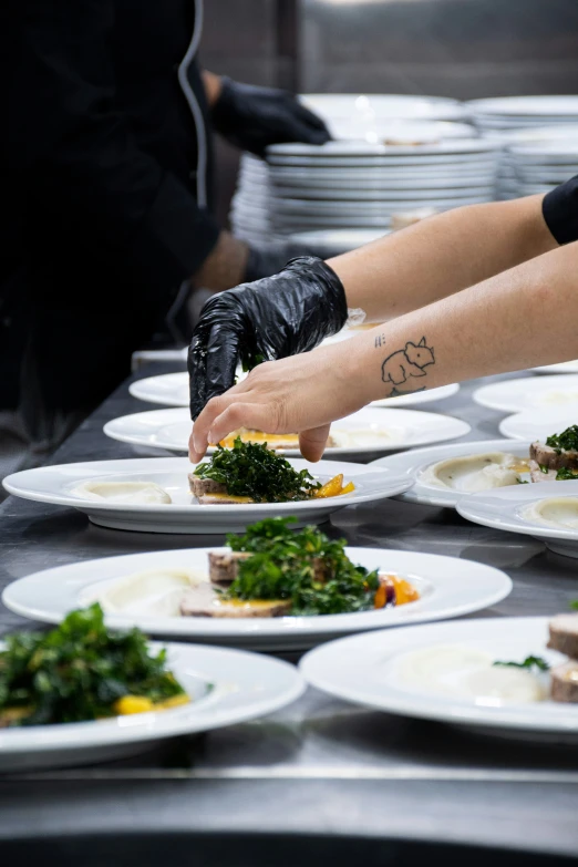 a cook puts toppings on plates to prepare food