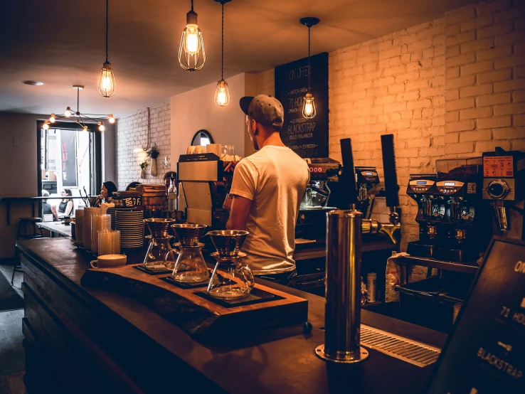 man working in coffee shop with a large selection of espresso machines