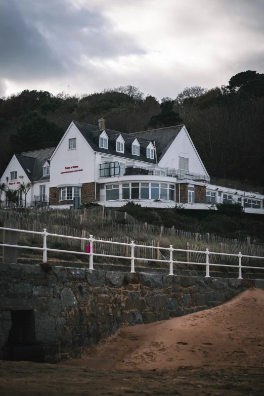 a house sits on top of a hill next to a gate