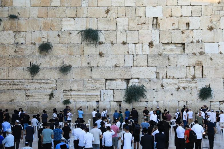 crowds gathered around the western wall and watching men talk