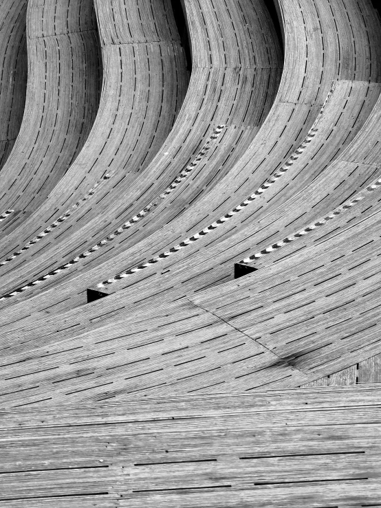 large wave like structure with two birds sitting in the foreground