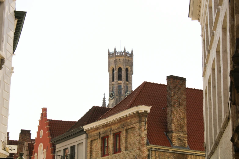 a view of some old brick buildings with a tower in the background