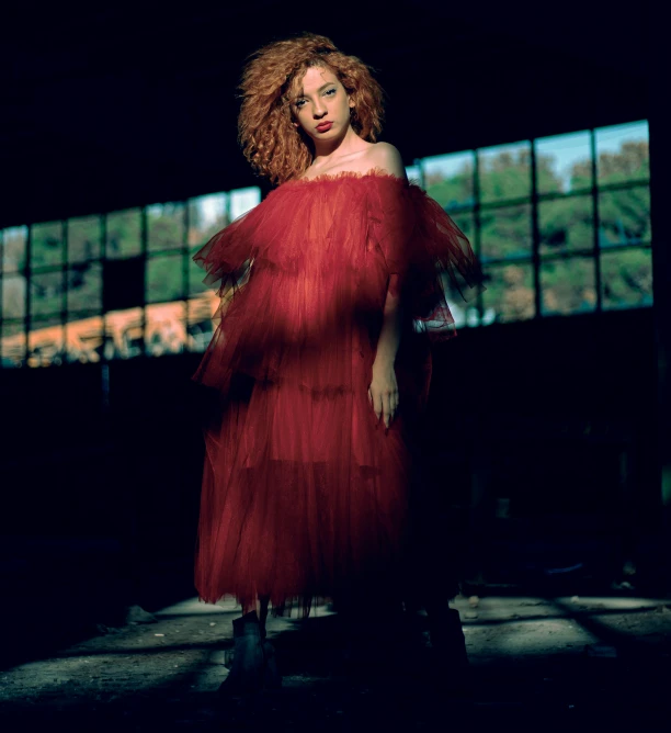 a woman with red hair in a long dress posing