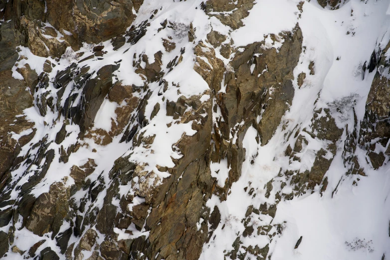 a close up of a snow covered mountain with rocks