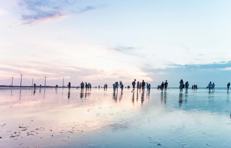 a group of people standing on top of a beach