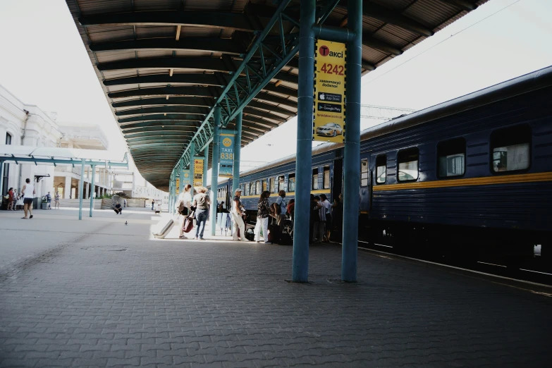 many people are outside waiting to board the train