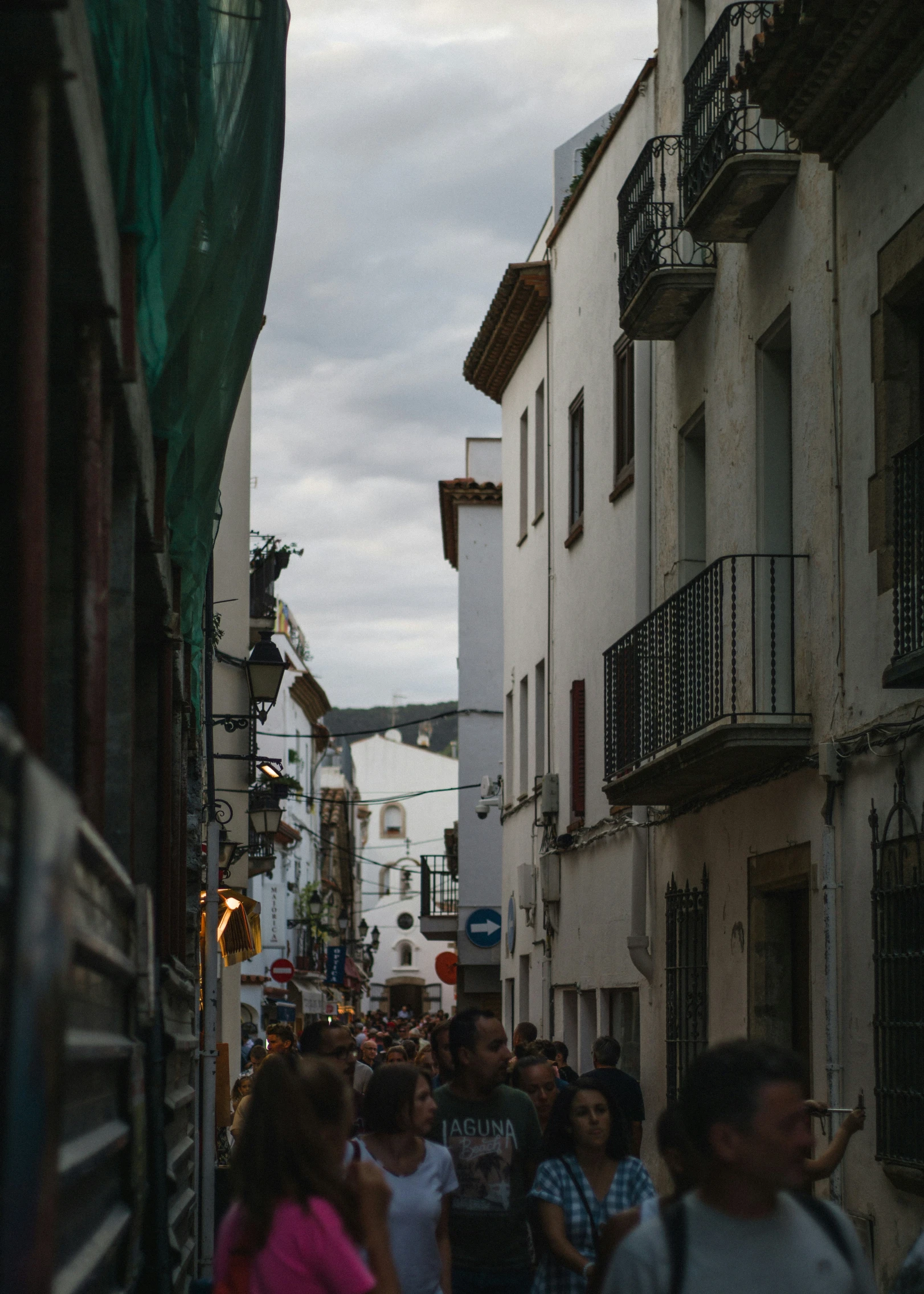 people are walking through an alley in an old town