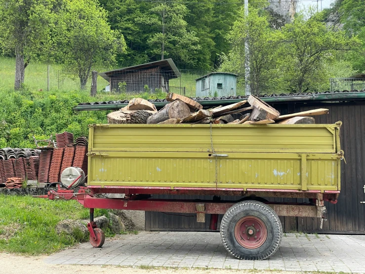 a yellow truck with logs sitting in the back