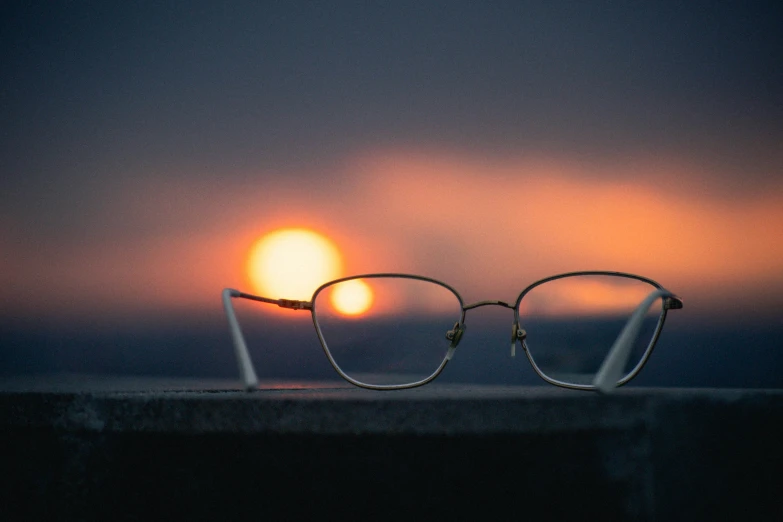 a pair of glasses sitting on top of a ledge