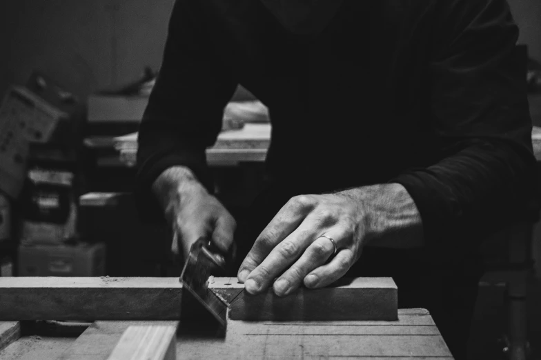 man carving soing on wooden board with knife