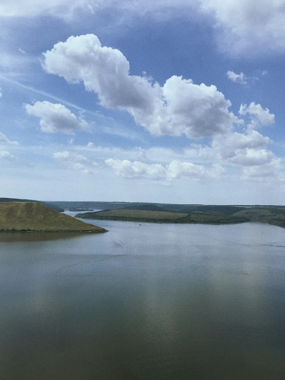a lake next to a hill on top of a hillside