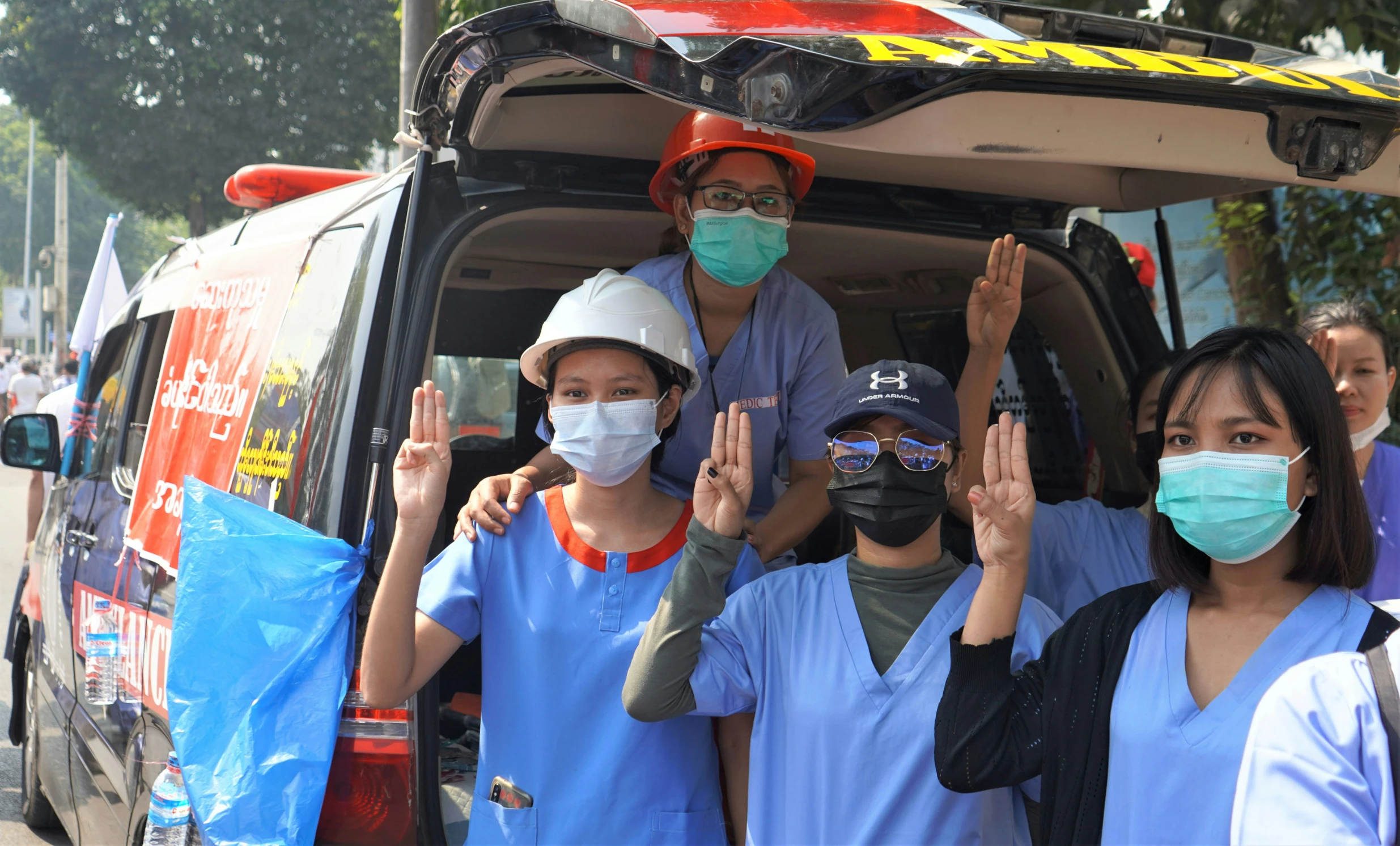 a group of people are getting on a van with masks