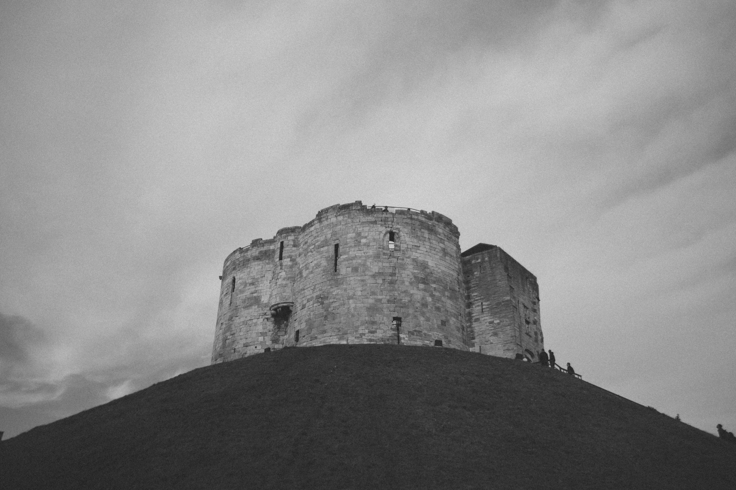 a very tall stone building with people in it