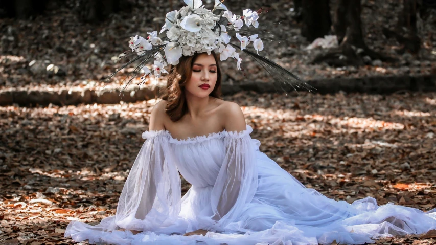 woman wearing white dress in woods with floral headpiece