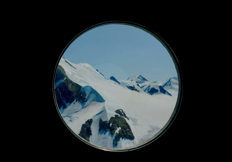 a snow covered mountain is seen in a circular picture