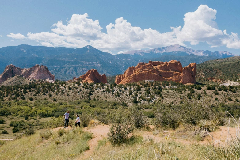 there are people hiking in the distance on the trail