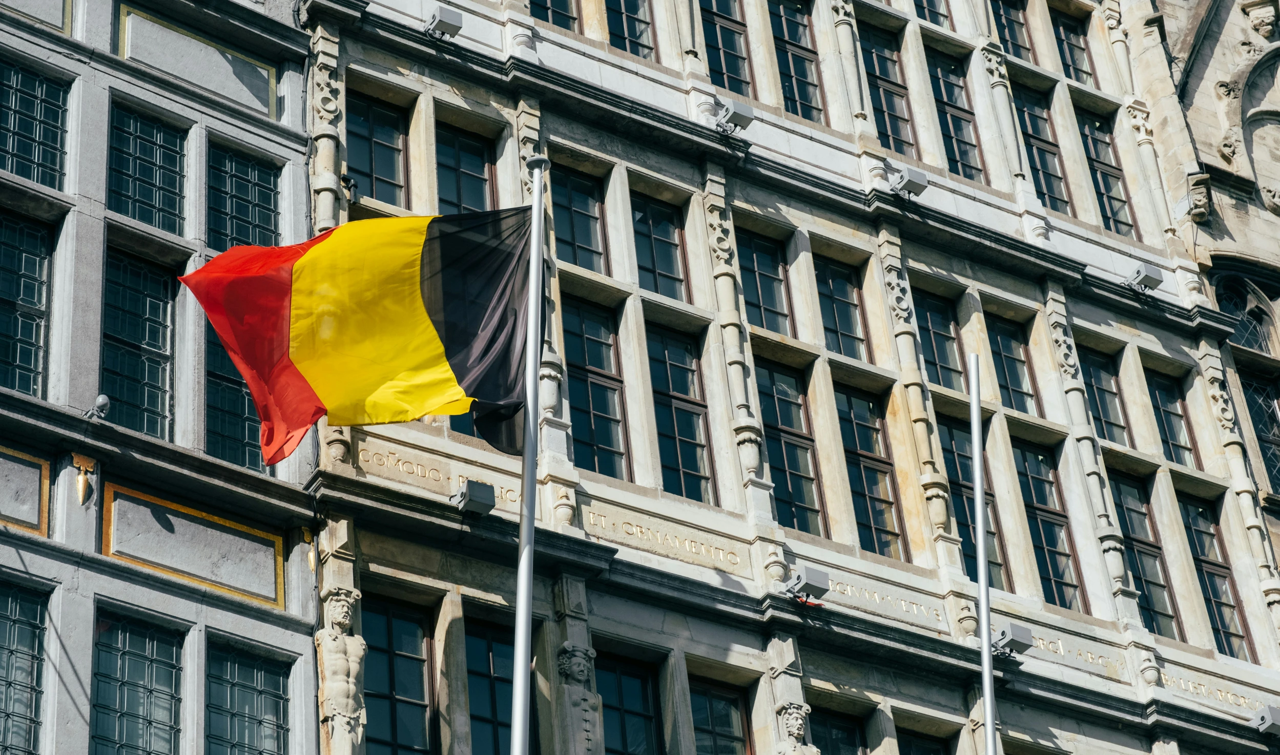 an old building with a big yellow and red flag on it