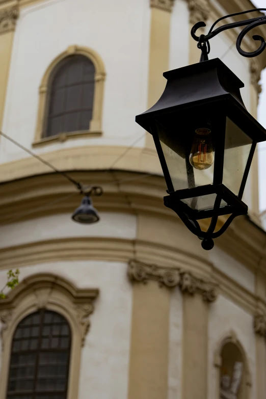 a lantern light hanging from the side of a building