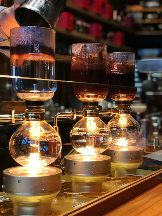 several blenders in a glass display case with lights on them