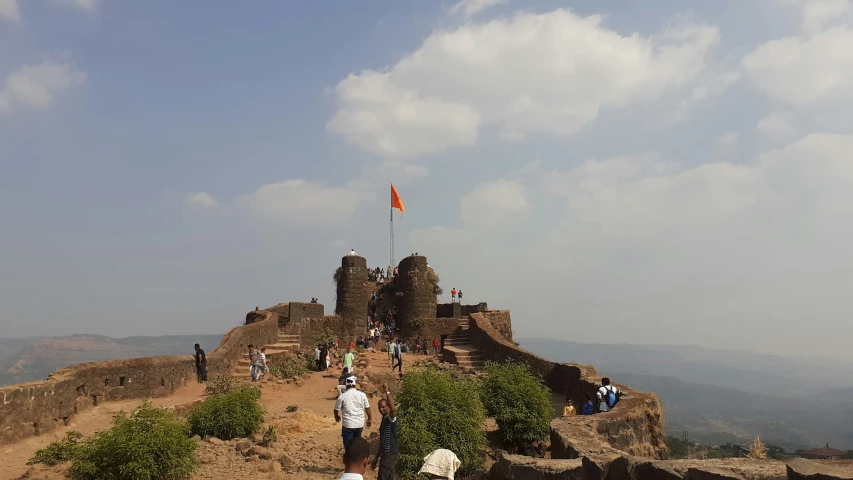 a group of people standing on top of a large stone building