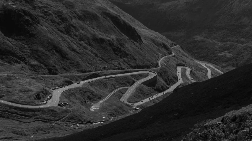 a very long winding road in the middle of some mountains