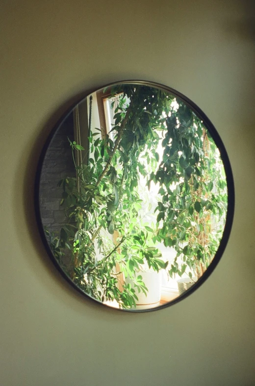 this is a circular mirror that is mounted on the wall