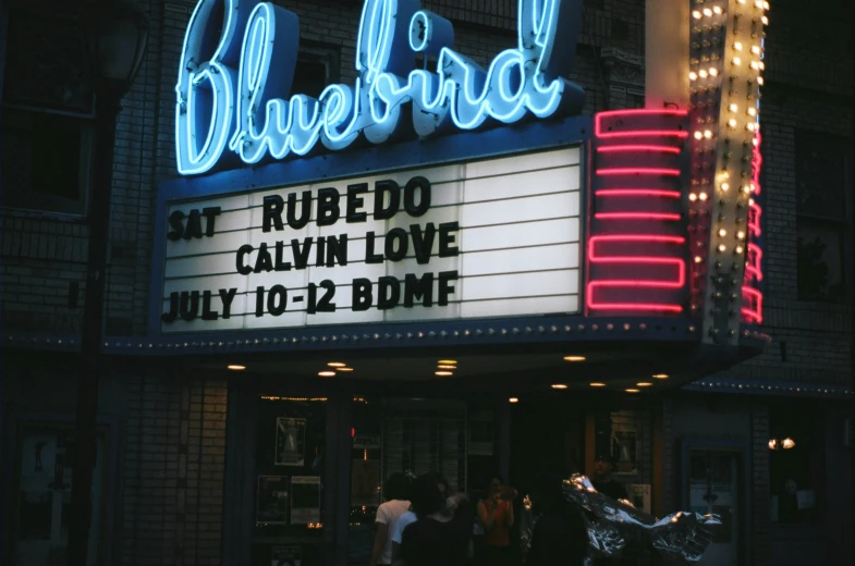 a theater marquee that has people standing outside