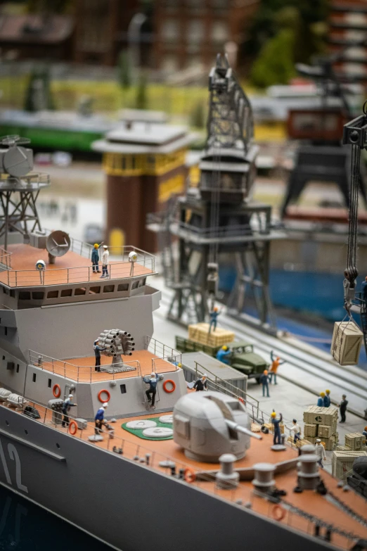 a model military ship in front of some construction equipment