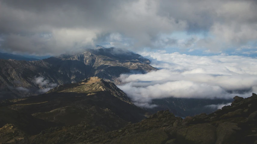 the mountains have clouds and some plants