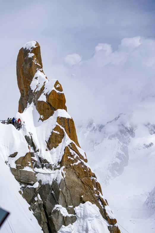 a group of people climb up the side of a snowy mountain