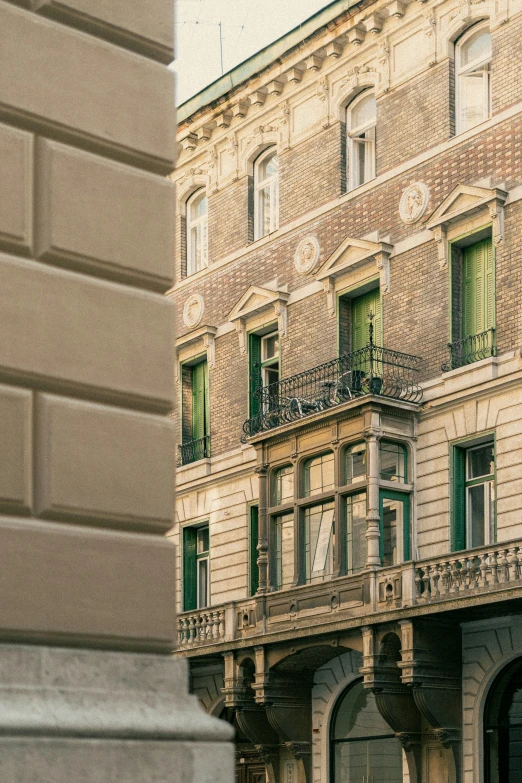 an old building that has green windows and lots of balconies