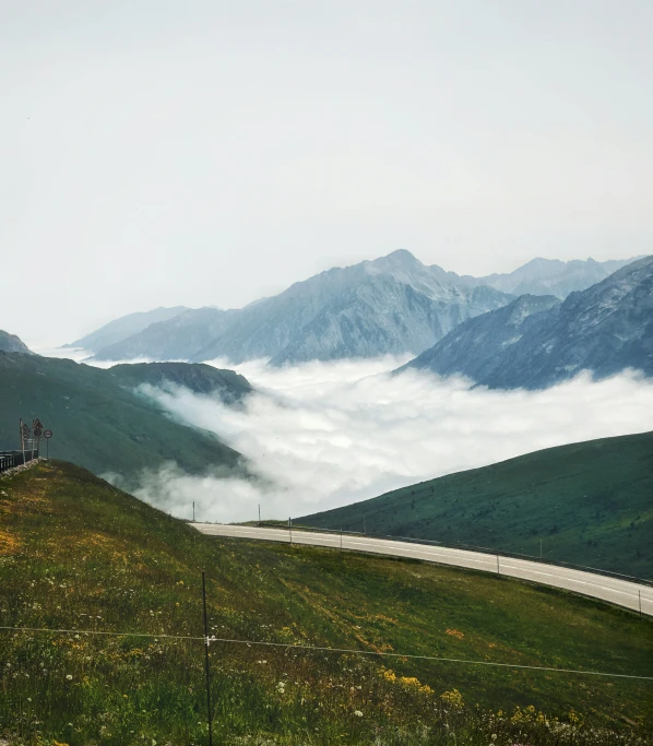 mountains are covered in a layer of cloud during the day