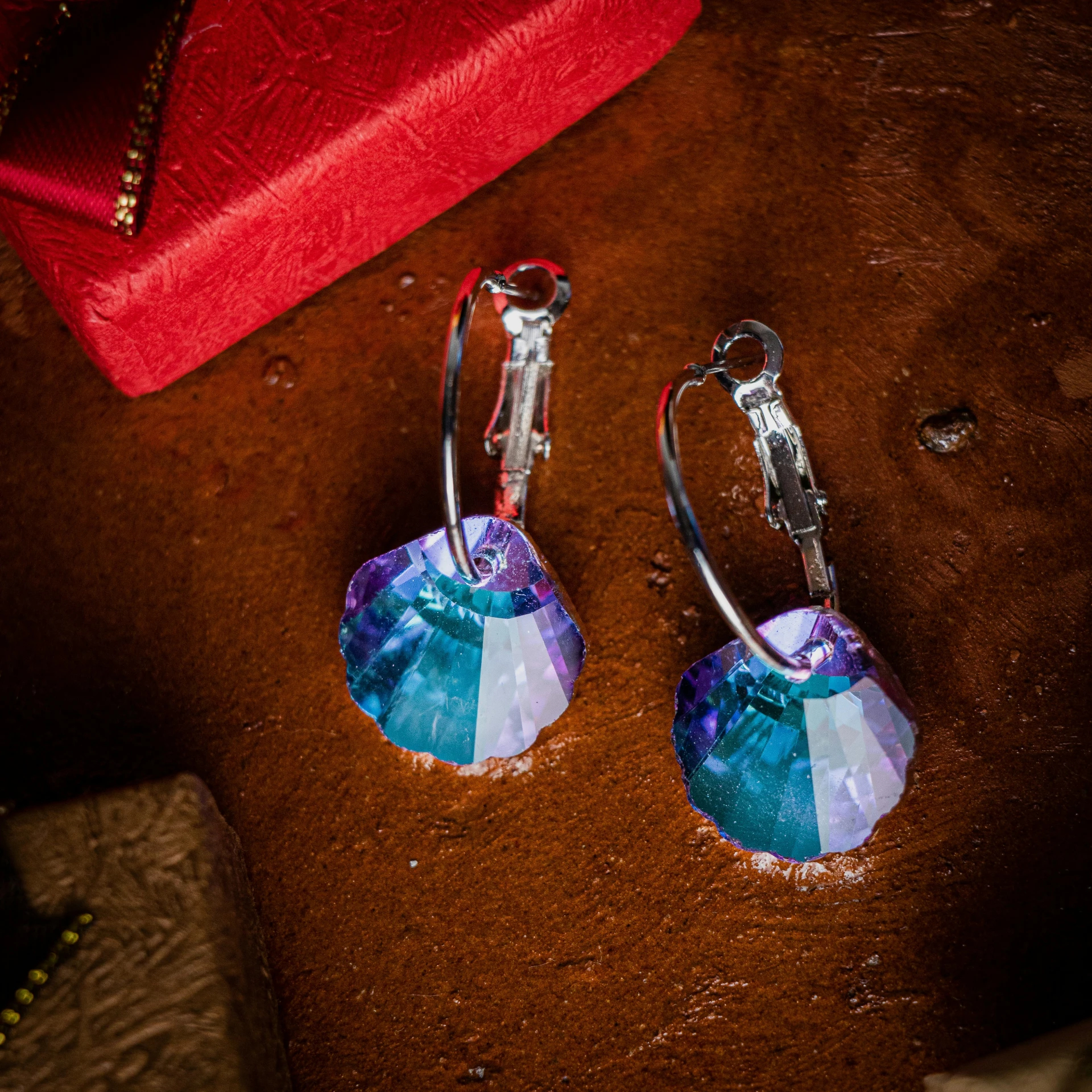 a pair of blue earrings on a table