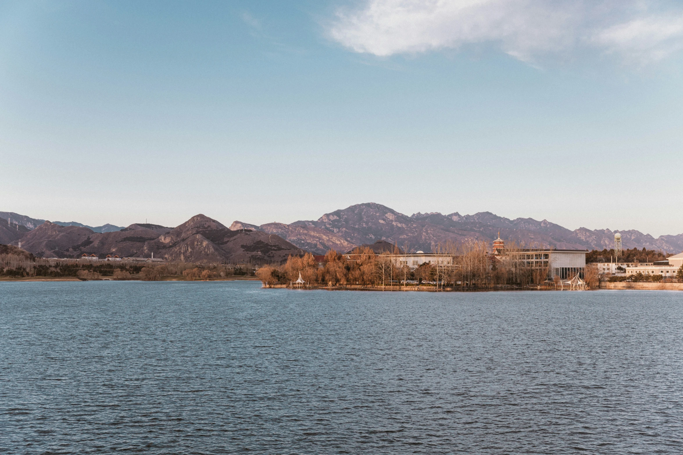 the mountain side and sky above the water are shown