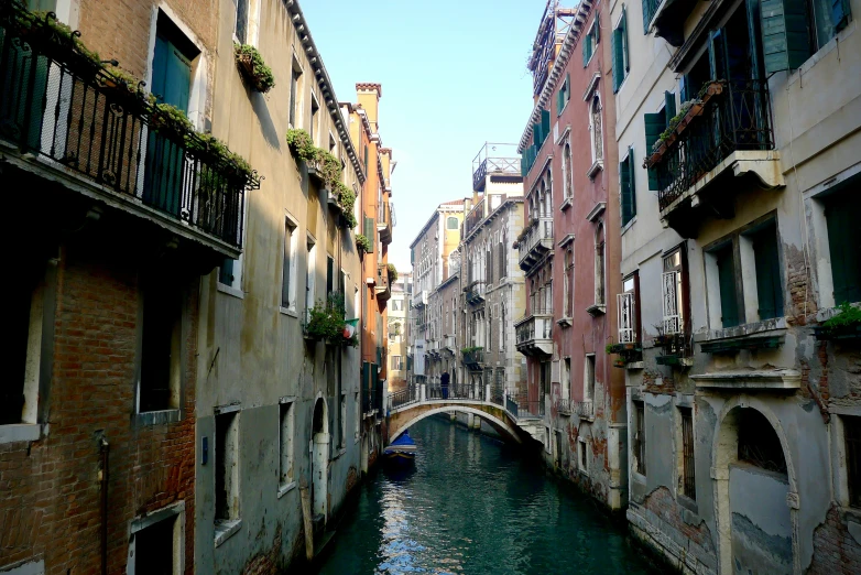 an old boat going down the canal between many buildings