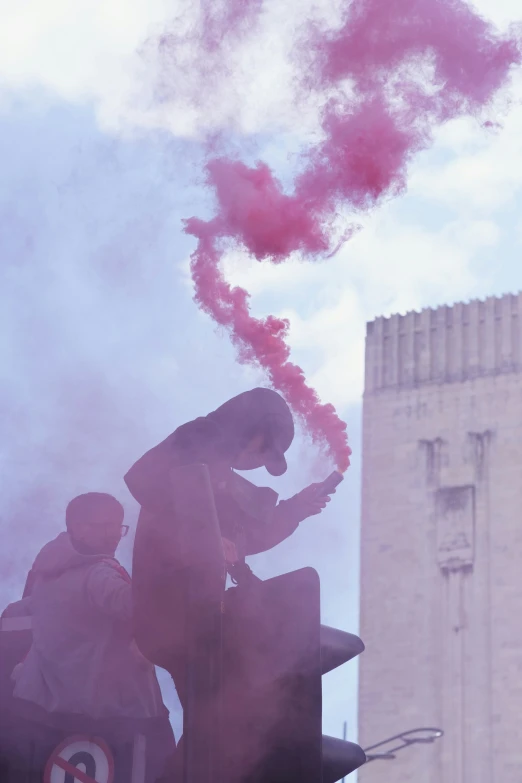 two people on a street light with smoke coming out of them